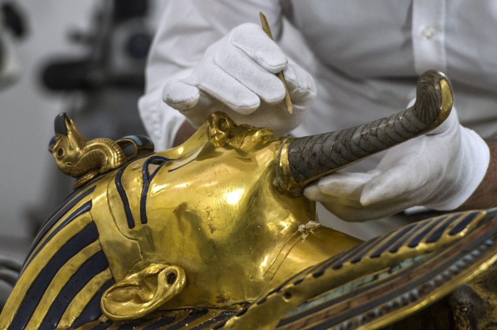 German specialists in restoration work on antiquities in glass and metal Christian Eckmann works on the restoration process of the golden mask of Tutankhamun at the Egyptian Museum in Cairo on October 20, 2015. Egypt started work to remove a crust of dried glue on the beard of legendary boy pharaoh Tutankhamun's golden mask after a botched repair job on the priceless relic. The beard fell off in an August 2014 accident at the Cairo Museum, and was clumsily reattached by employees. Photo credit should read Khaled Desouki/AFP/Getty Images.