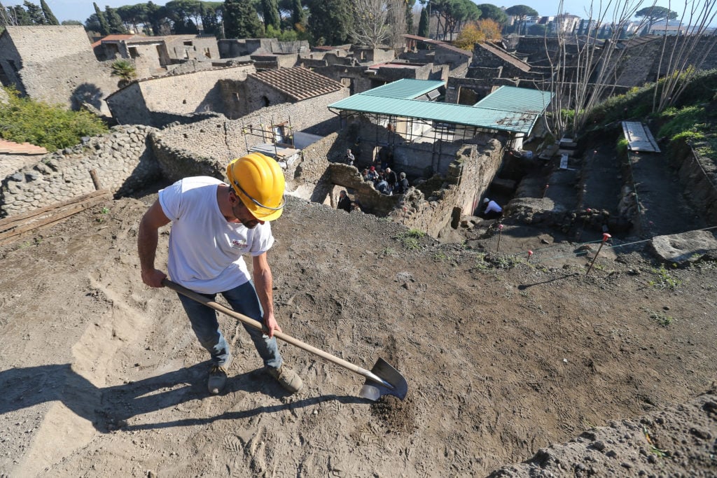 Restorer at work in the Schola Armaturarum, the first excavation of Pompeii in an area that has never been investigated, after more than 20 years, in 2012. Photo by Marco Cantile/LightRocket/Getty Images.