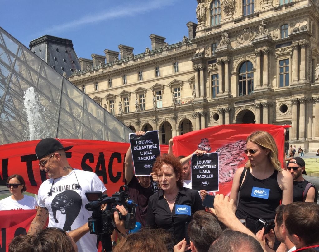 Nan Goldin speaking at the protest outside the Louvre. Photo courtesy Sackler P.A.I.N.
