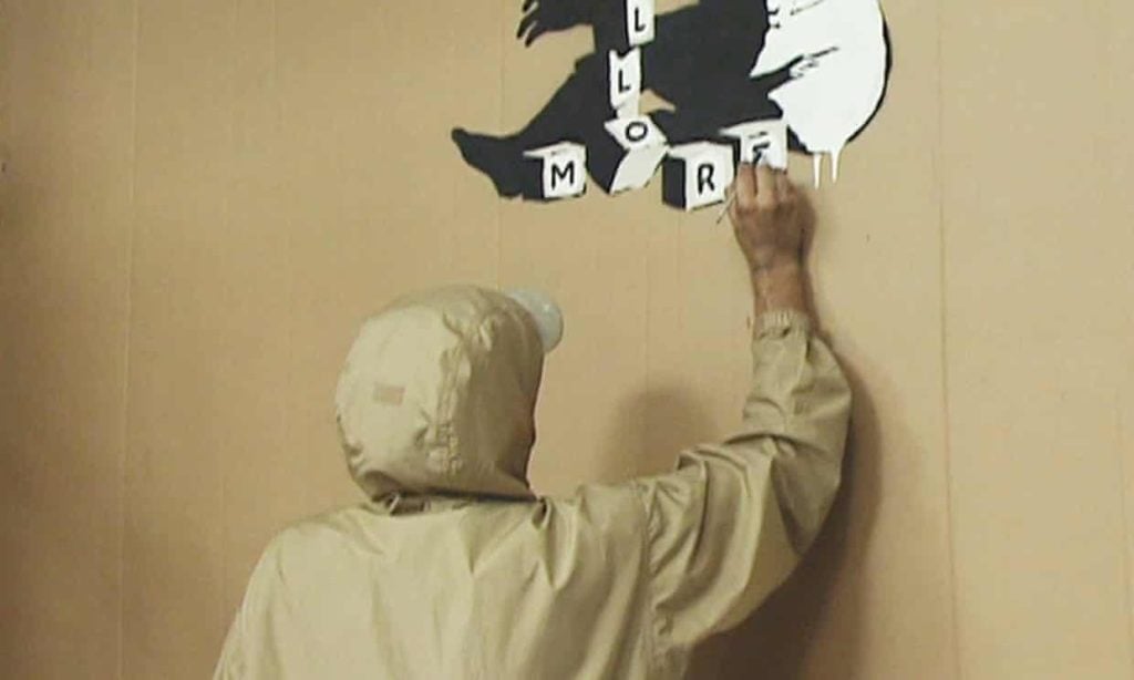 A young man who identified himself as Banksy was interviewed on camera and filmed creating known works by the anonymous British street artist at his first major show "Turf War," in 2003. This is a screen grab from the interview with ITV News.