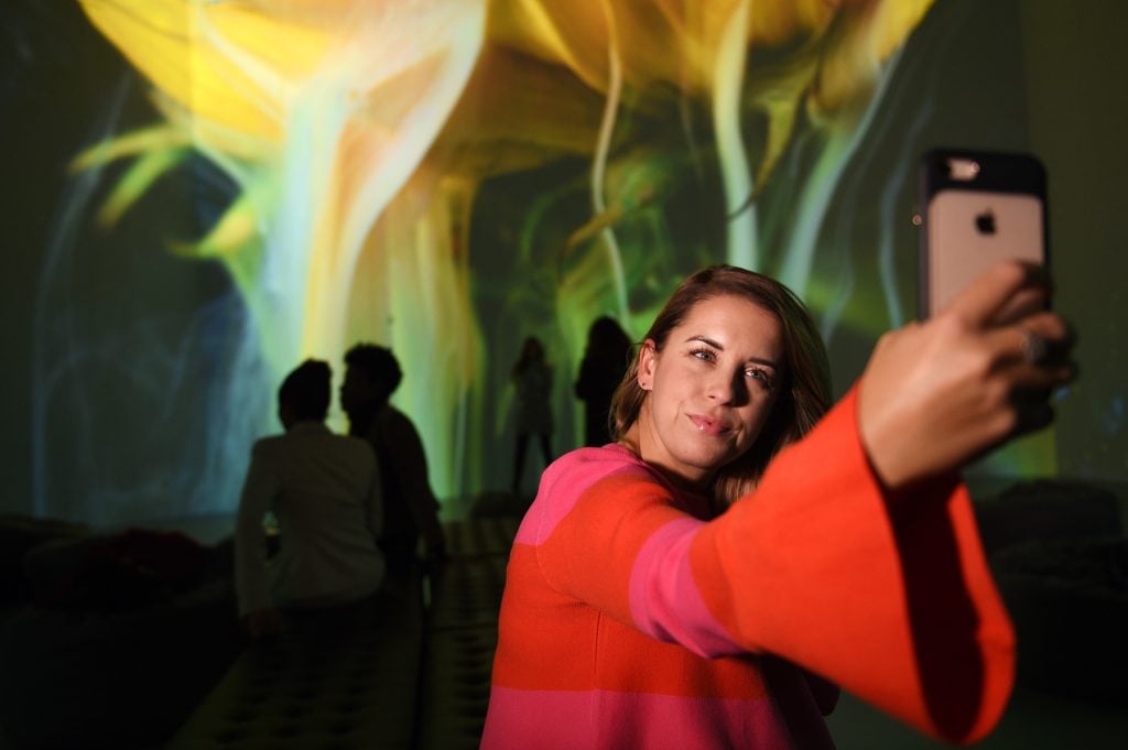 A visitor from Leesburg, VA, takes a selfie with her iPhone while visiting the Artechouse, in Washington, D.C., November 8, 2017. Photo courtesy Astrid Riecken For The Washington Post via Getty Images.