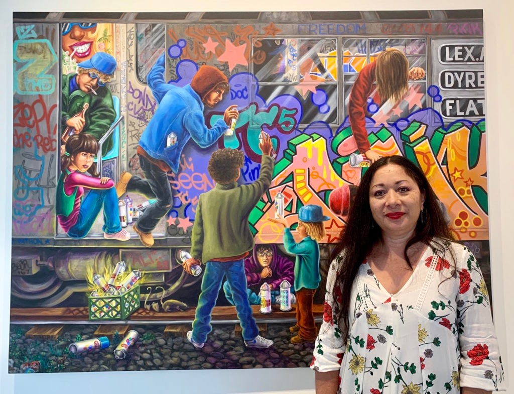 Lady Pink with her painting <em>TC5 Teamwork</em> (2018) at "Beyond the Streets." Photo courtesy of Sarah Cascone. 