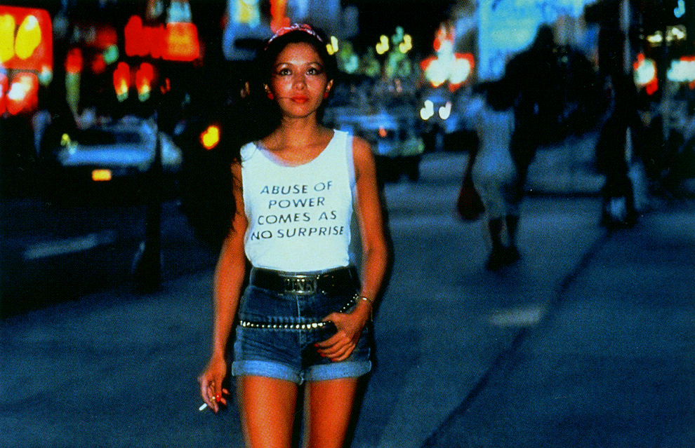 Lisa Kahane, Lady Pink photographed in Times Square (1983), wearing a t-shirt from Jenny Holzer’s 