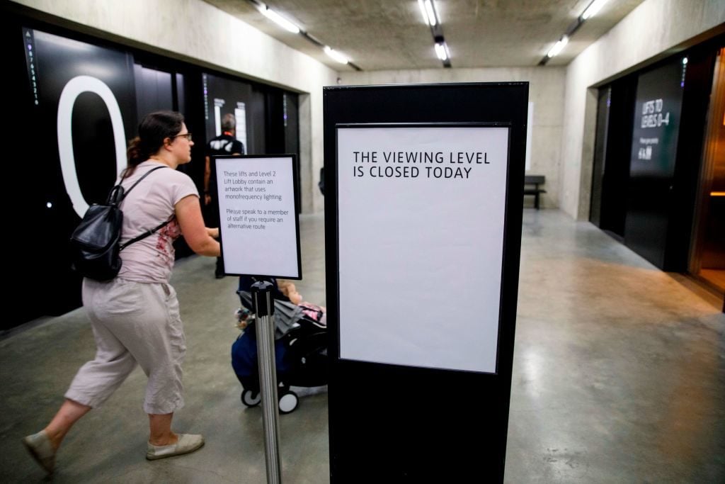 Visitors walk by a sign at Tate Modern that explains that the viewing level is closed following a six-year-old boy being thrown from the balcony on Sunday. Photo by Tolga Akmen/AFP/Getty Images.