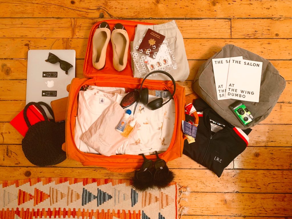 Lolita's suitcase featuring a selection of t-shirts, a pair of Repettos, sunglasses and her inflatable stool. Photo courtesy Lolita Cros.
