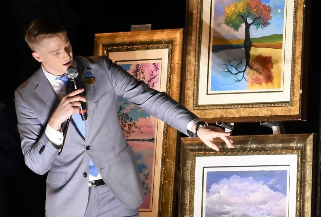 Park West art auctioneer Alex White offering works including a tree painting by David Najar. Photo by Park West.