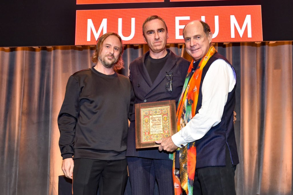Left to right: Sterling Ruby, friend and fashion confidant Raf Simons, and American Folk Art Museum president Monty Blanchard at the museum's 2018 fall benefit gala. (Photo by Sean Zanni/Patrick McMullan via Getty Images)