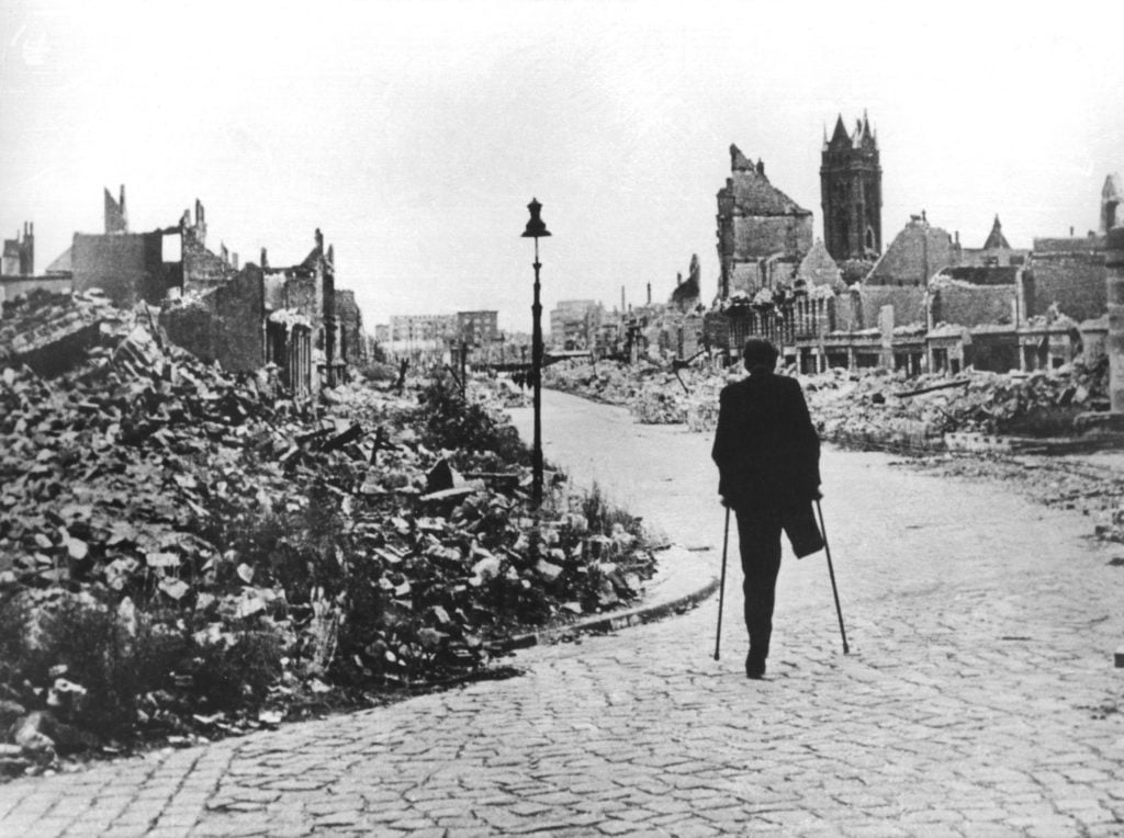 A man traverses Hamburg in the wake of World War II. (Photo by dpa/picture alliance via Getty Images)