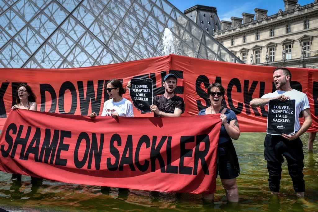 Activists of P.A.I.N. (Prescription Addiction Intervention Now) protest the Sacklers at the Louvre. Photo by Stephane de Sakutin/AFP/Getty Images.