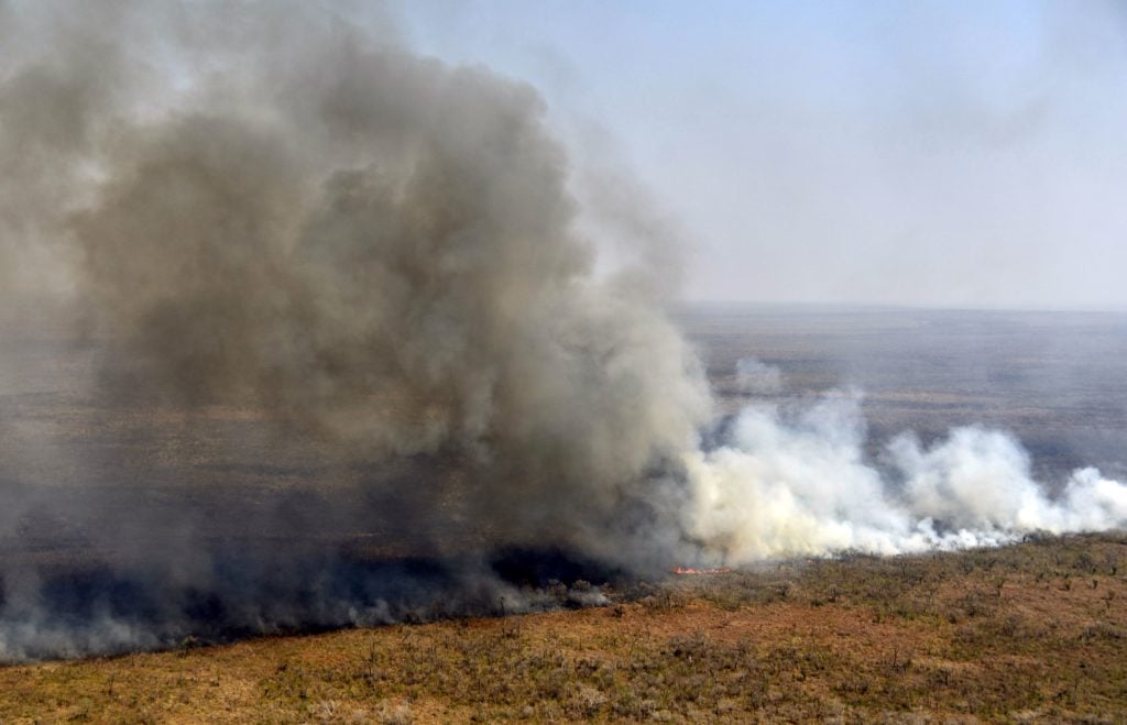 Aerial view of smoke billowing from a fire near Charagua in Bolivia, on the border with Paraguay, south of the Amazon basin, on August 29, 2019. Fires have destroyed 1.2 million hectares of forest and grasslands in Bolivia this year, the government said on Wednesday, although environmentalists claim the true figure is much greater. (Photo by Aizar Raldes/AFP/Getty Images.