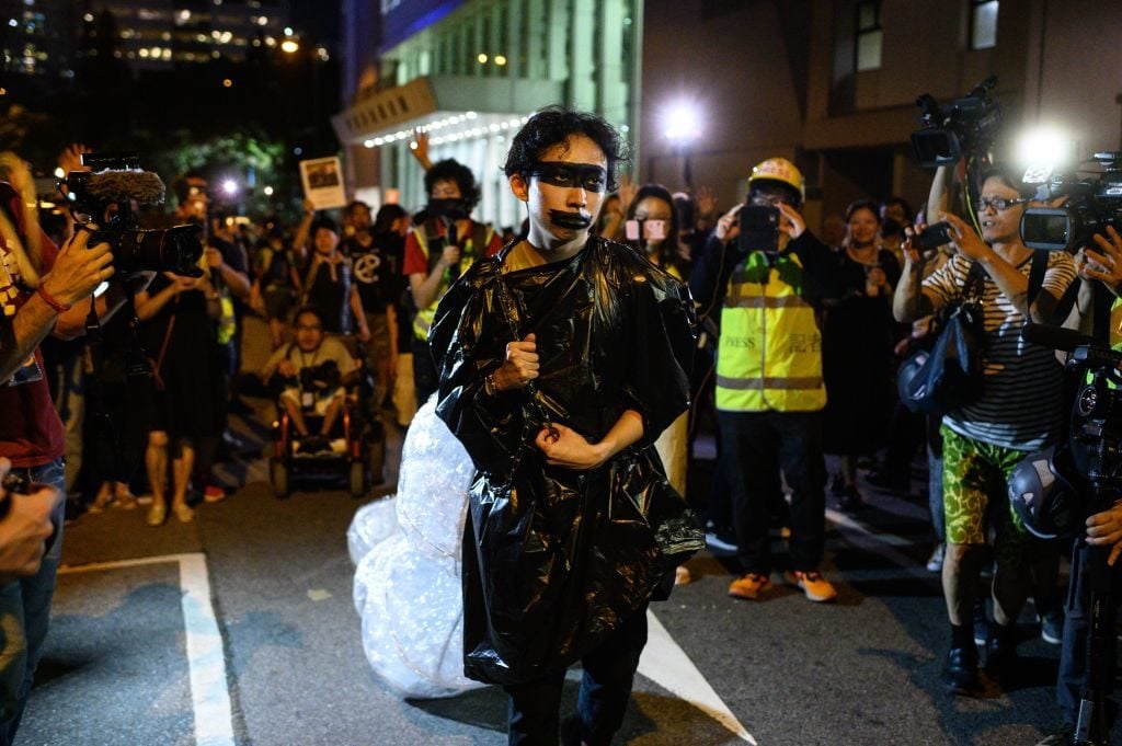 A protester in plastic joins others as people gather outside the Queen Elizabeth Stadium in Hong Kong's Wanchai district on September 26, 2019. (Photo: PHILIP FONG/AFP/Getty Images)