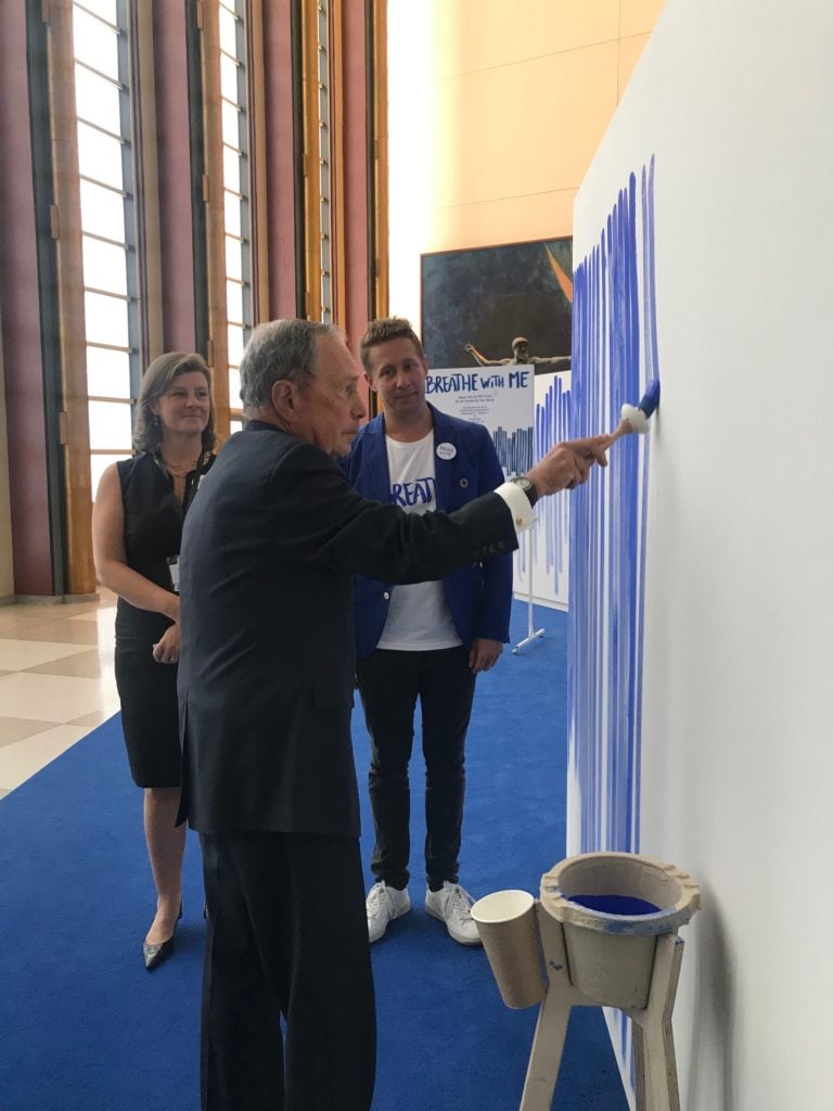 Jeppe Hein and ART2030 founder Luise Faurschou watch Michael Bloomberg add to Hein's <em>Breathe With Me</eM> (2019) at the United Nations Headquarters, New York. Photo courtesy of the artist and ART2030.