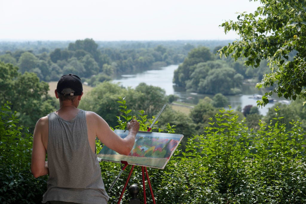 An artist paints the Thames River in Richmond in the UK. (Photo by Sam Mellish / In Pictures via Getty Images Images)
