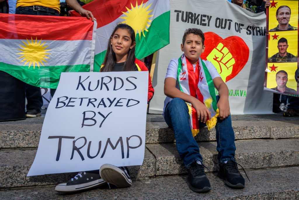 A child holding a protest sign at the Save Rojava rally in New York. Photo: Erik McGregor/LightRocket via Getty Images.