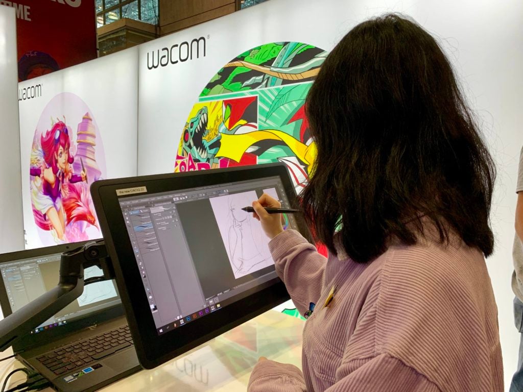A woman tests out a Wacom table at New York Comic Con. Photo by Sarah Cascone. 