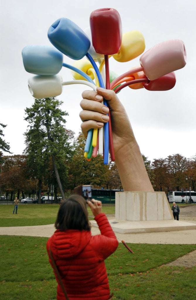 A visitor takes a picture of Bouquet of Tulips by Jeff Koons. Photo by Chesnot/Getty Images.