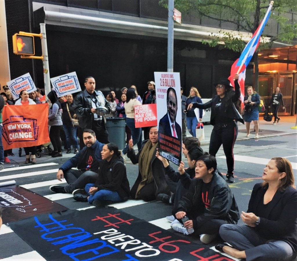 #CancelTheDebt protesters from New York Communities for Change sit in in front of the Museum of Modern Art on October 21.<br> Image: Eileen Kinsella.
