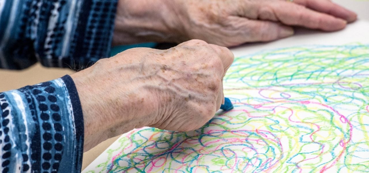 A woman with dementia create an image to the sound of classical music at the Staedel Museum in Frankfurt. Germany, 2015. Photo: Alexander Heinl, dpa/picture alliance via Getty Images.