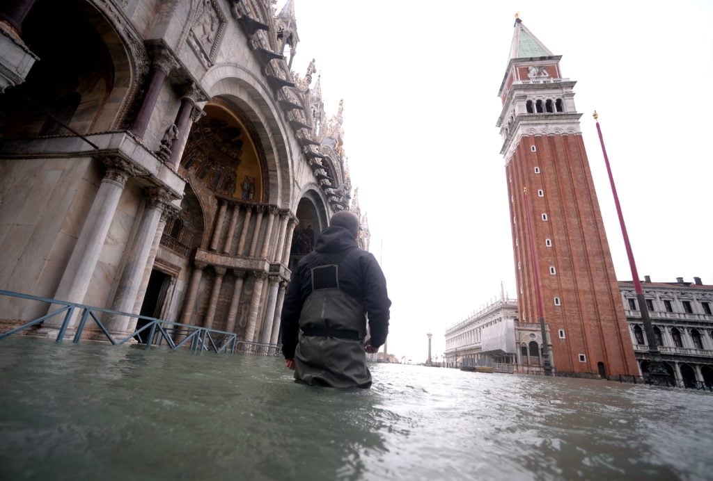 A man walks in flooded St. Mark square in Venice, during "acqua alta", or high water, of 160 centimetres (over five feet), on November 17, 2019. - Venice was braced on November 17 for an unprecedented third major flooding in less than a week, with sea water due to swamp the already devastated historic city where authorities have declared a state of emergency. (Photo by FILIPPO MONTEFORTE/AFP via Getty Images)