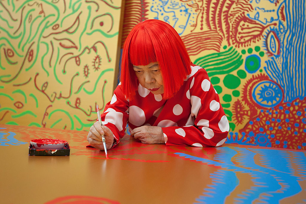 Japanese artist Yayoi Kusama working on a painting. Photo by Jeremy Sutton-Hibbert/Getty Images.