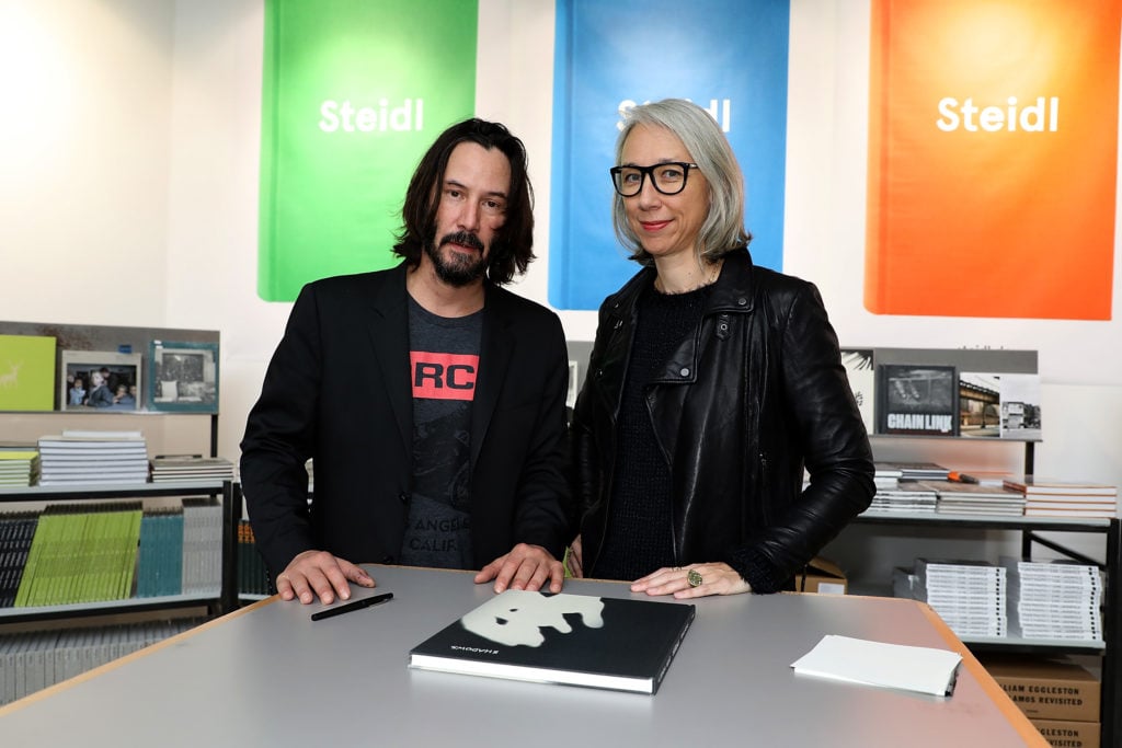 Actor Keanu Reeves and Artist Alexandra Grant posing by their book Ode to Happiness. Photo by Pierre Suu/GC Images.