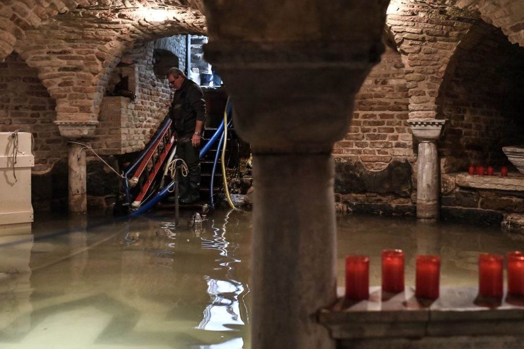 A man pumps out water from the flooded crypt of St. Mark's Basilica after the floods on November 12. Photo by Marco Bertorello/AFP via Getty Images.