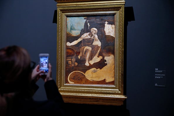 A visitor snaps a picture of Da Vinci's <i>Saint Jerome praying in the Wilderness</i> at the Louvre. There are only 15 paintings attributed to the Italian Renaissance master, and the Louvre is showing 11 of them.