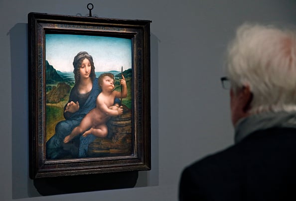 A visitor to the Louvre looks at The Virgin and the Child by Leonardo da Vinci. Photo by Chesnot/Getty Images.