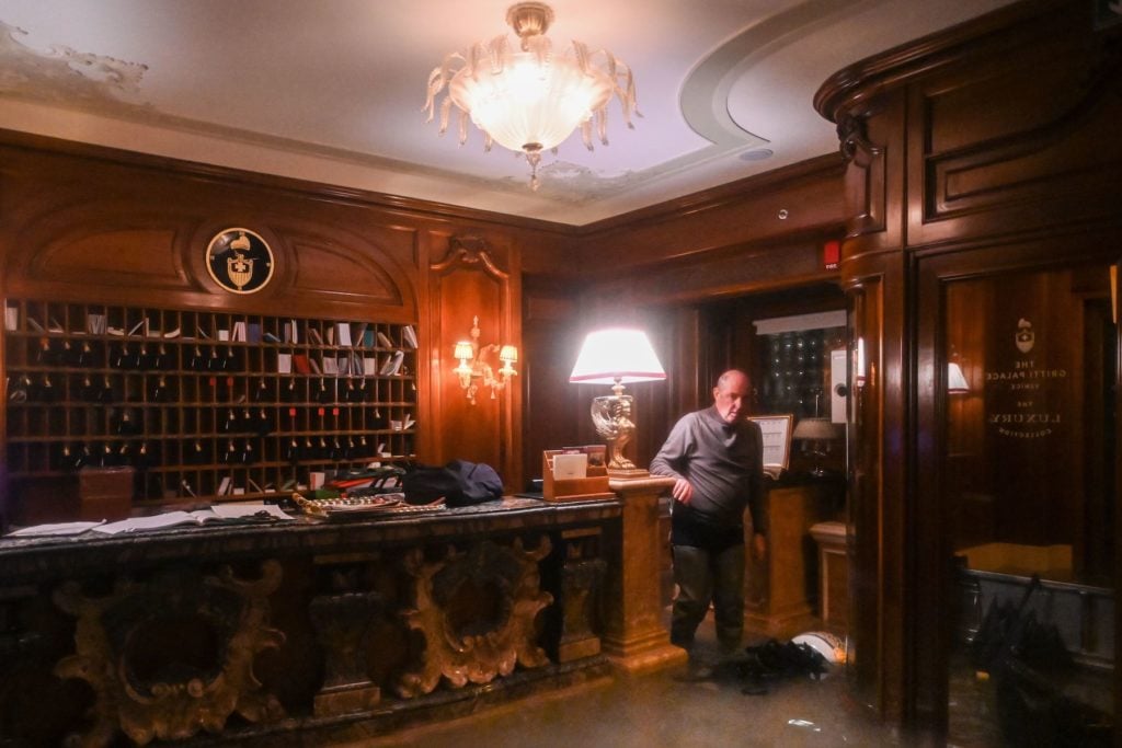 An employee stands by the flooded front desk of the Gritti Palace the floods November 12. Photo by Marco Bertorello/AFP via Getty Images.