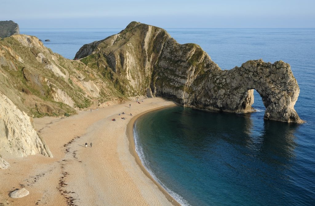 The Durdle Door, a natural limestone arch on the Jurassic Coast near Lulworth in Dorset, England. Photo by Saffron Blaze, Creative Commons <a href=https://creativecommons.org/licenses/by-sa/3.0/ target="_blank" rel="noopener">Attribution-Share Alike 3.0 Unported</a> license.