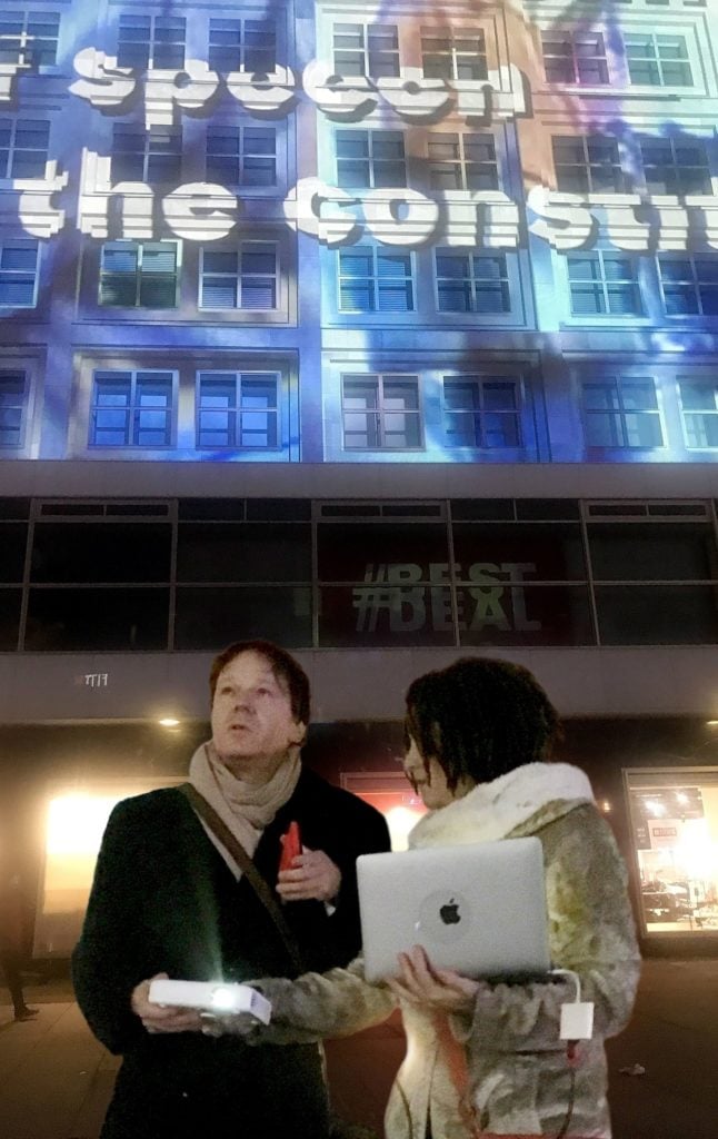 David Graeber and Nika Dubrovsky with the Yes Women projection in Alexanderplatz. Image courtesy the Yes Women.