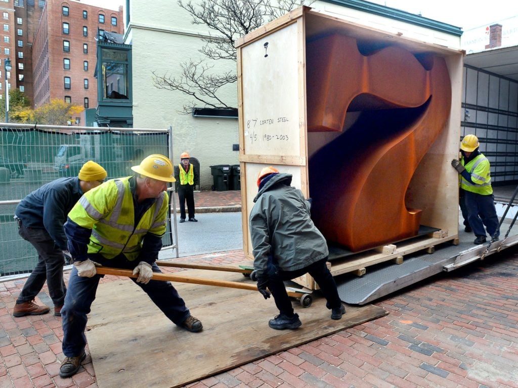 Workers remove the sculpture from its packing crate as the Portland Museum of Art installs an 8 foot tall steel "Seven" sculpture by Robert Indiana. Photo by John Patriquin/Portland Portland Press Herald via Getty Images.
