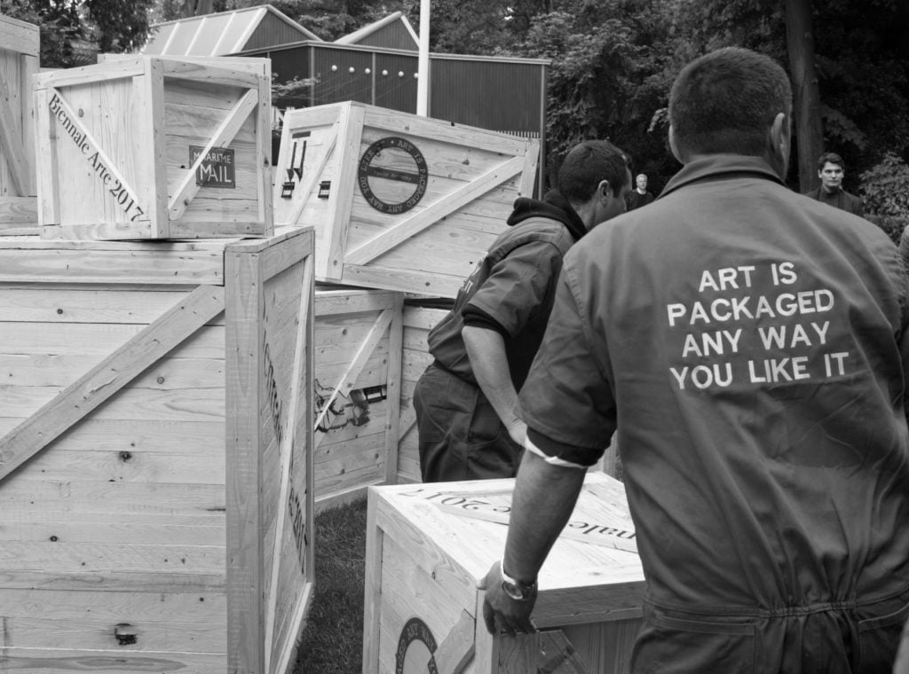 Workers transport wooden crates containing artwork at the Biennale Giardini on May 11, 2017 in Venice, Italy. Photo by Marco Secchi/Getty Images.