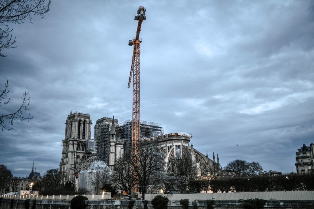 A photograph taken on December 26, 2019, shows a giant crane outside the Notre-Dame Cathedral in Paris, which was partially destroyed when fire broke out beneath the roof on April 15, 2019. (Photo by STEPHANE DE SAKUTIN / AFP) (Photo by STEPHANE DE SAKUTIN/AFP via Getty Images)
