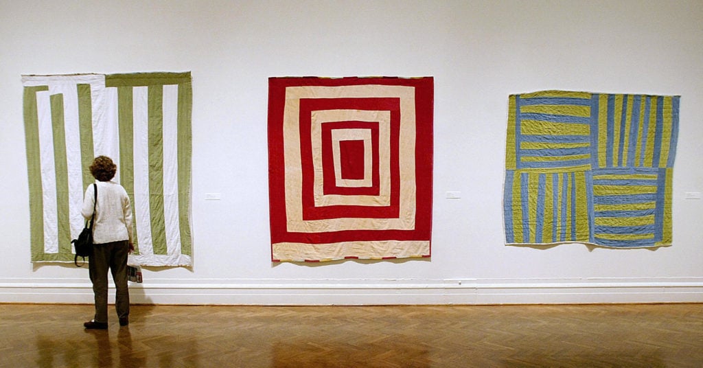 A visitor looks at the "The Quilts of Gee's Bend" exhibit at the Corcoran Gallery of Art 19 February, 2004, in Washington, DC.(STEPHEN JAFFE/AFP via Getty Images)