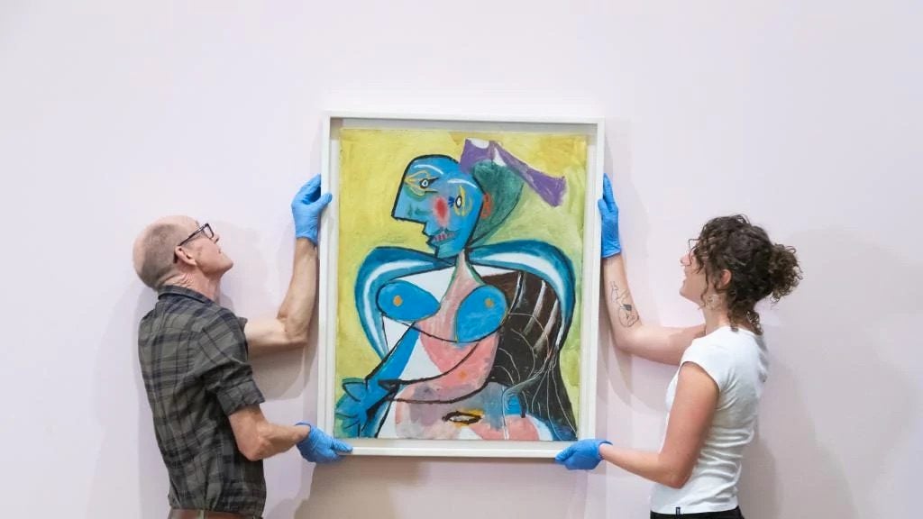 Art handlers at the National Gallery of Australia install Pablo Picasso's <em>L'Arlésienne: Lee Miller</em> (1937). Private international collection ©Succession Picasso/Copyright Agency. Photo courtesy of the National Gallery of Australia. 