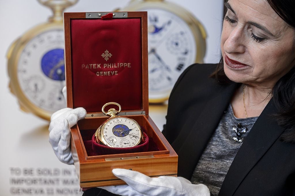 Sotheby's head of International Watch Division Daryn Schnipper holds the Henry Graves Supercomplication timepiece by Patek Philippe. Photo courtesy of FABRICE COFFRINI/AFP via Getty Images.