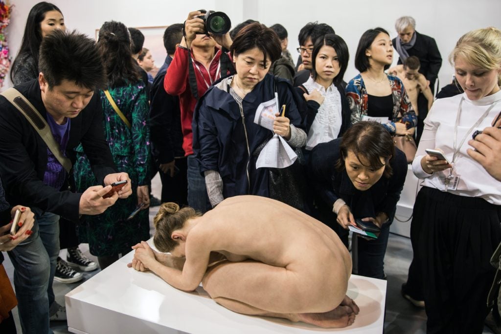 Visitors crowd around Australian artist Sam Jinks's <i>Untitled (Kneeling Woman)</i> at Art Basel Hong Kong 2015. AFP PHOTO / ANTHONY WALLACE<br /> <br />