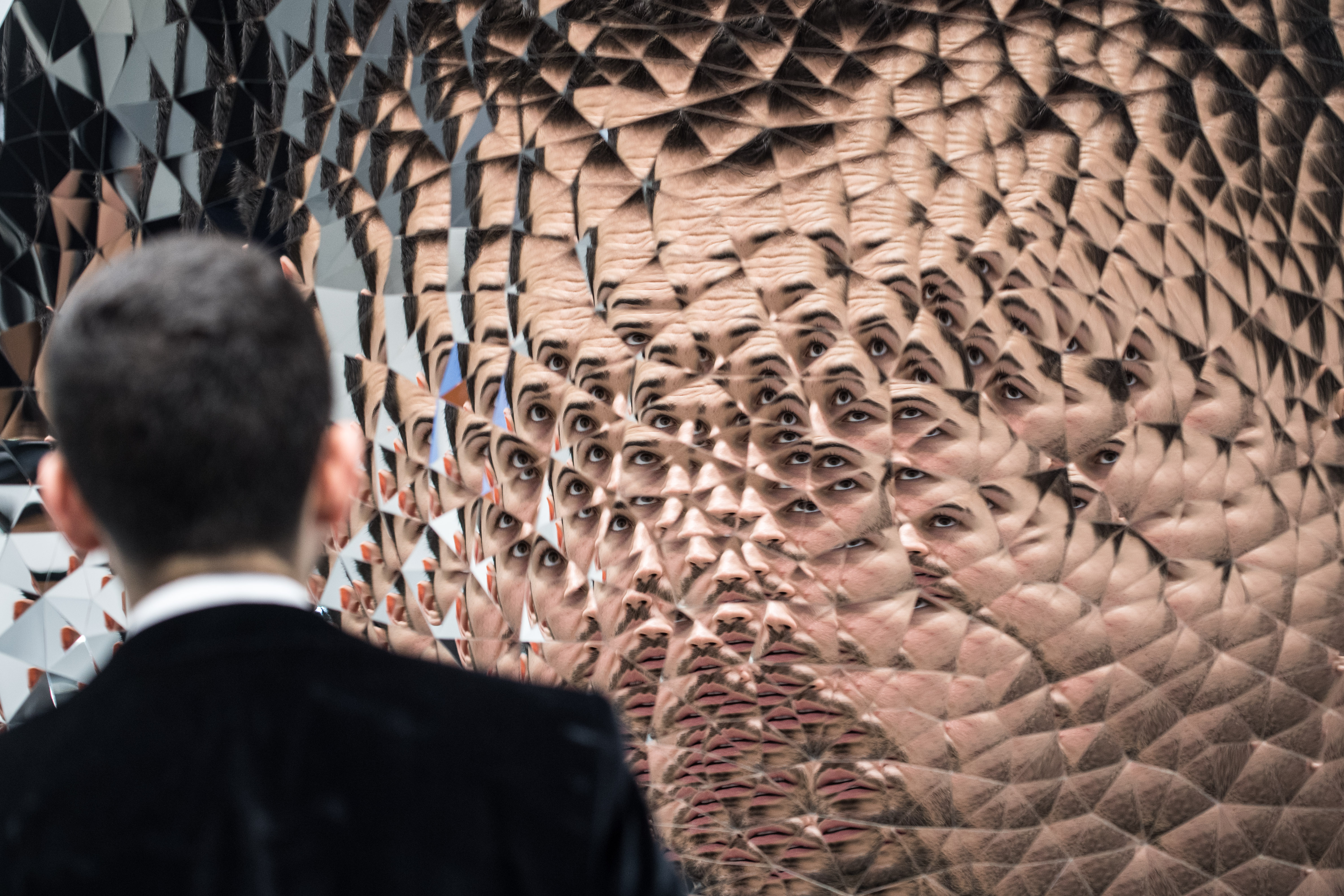 A visitor examines Anish Kapoor's Random Triangle Mirror at Art Basel in Hong Kong in 2016. (ANTHONY WALLACE/AFP via Getty Images)