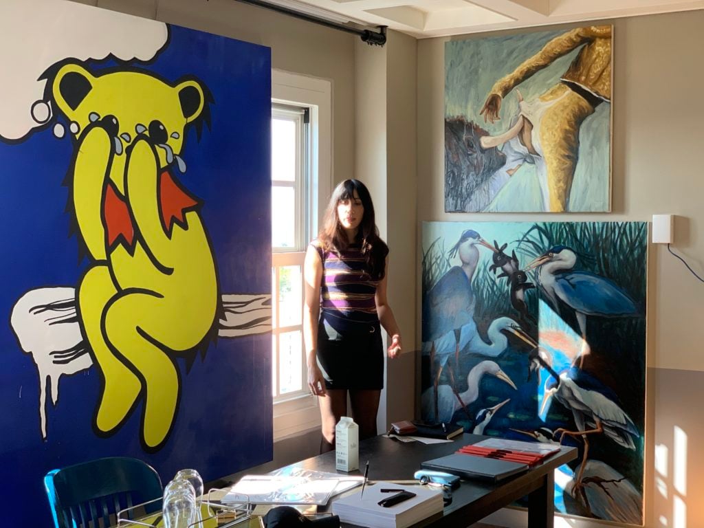Berlin painter Tina Braegger's Grateful Dead bear painting; eminently cheerful LA native and booth assistant Lucrecia Roa; and paintings by Manila-based artist Bree Jonson. Photo by Kenny Schachter.