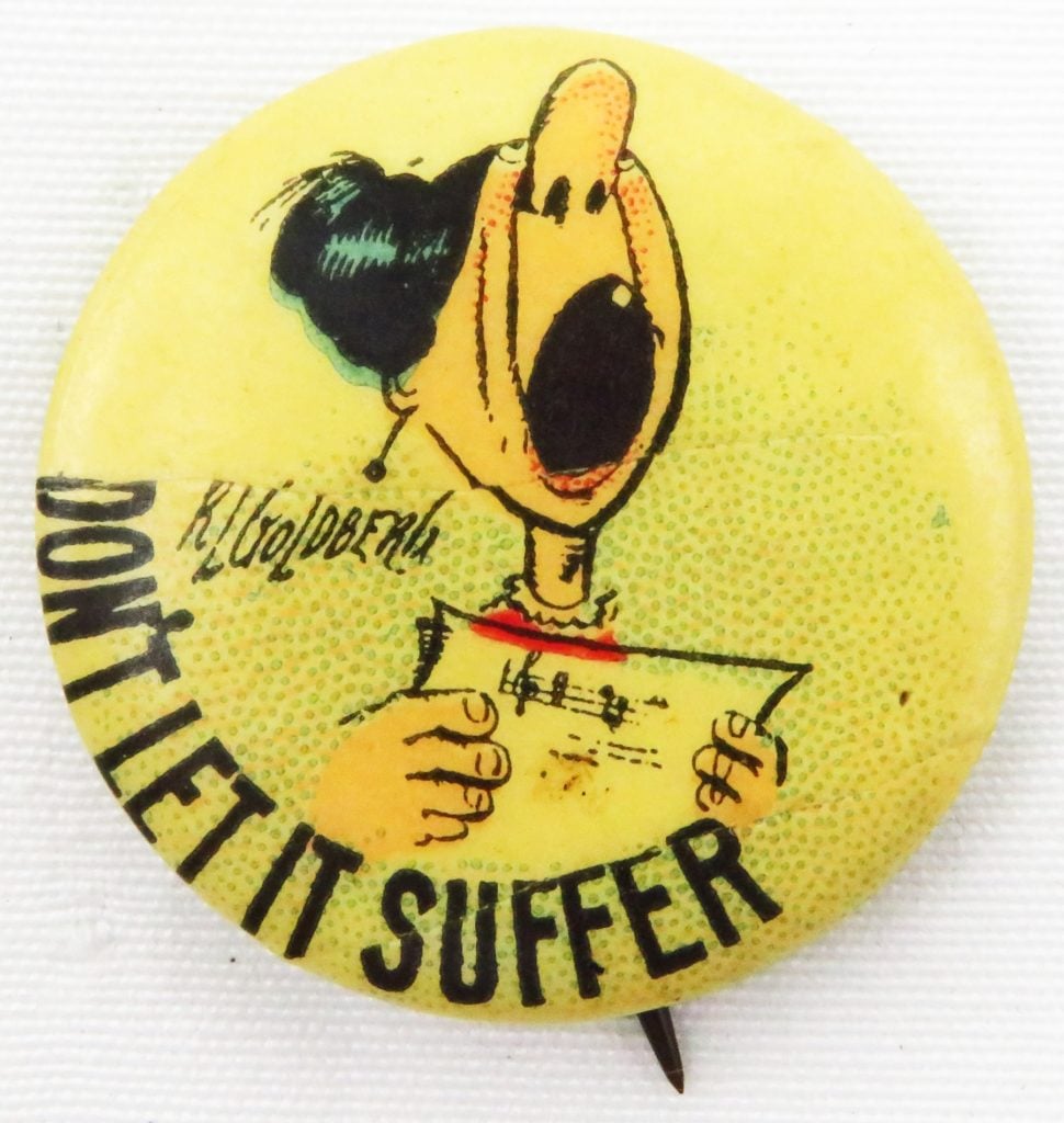 Anti-suffrage button with a Rube Goldberg cartoon satirically depicting a singing woman, with the text 'Don't Let It Suffer.' Photo by Ken Florey Suffrage Collection/Gado/Getty Images.