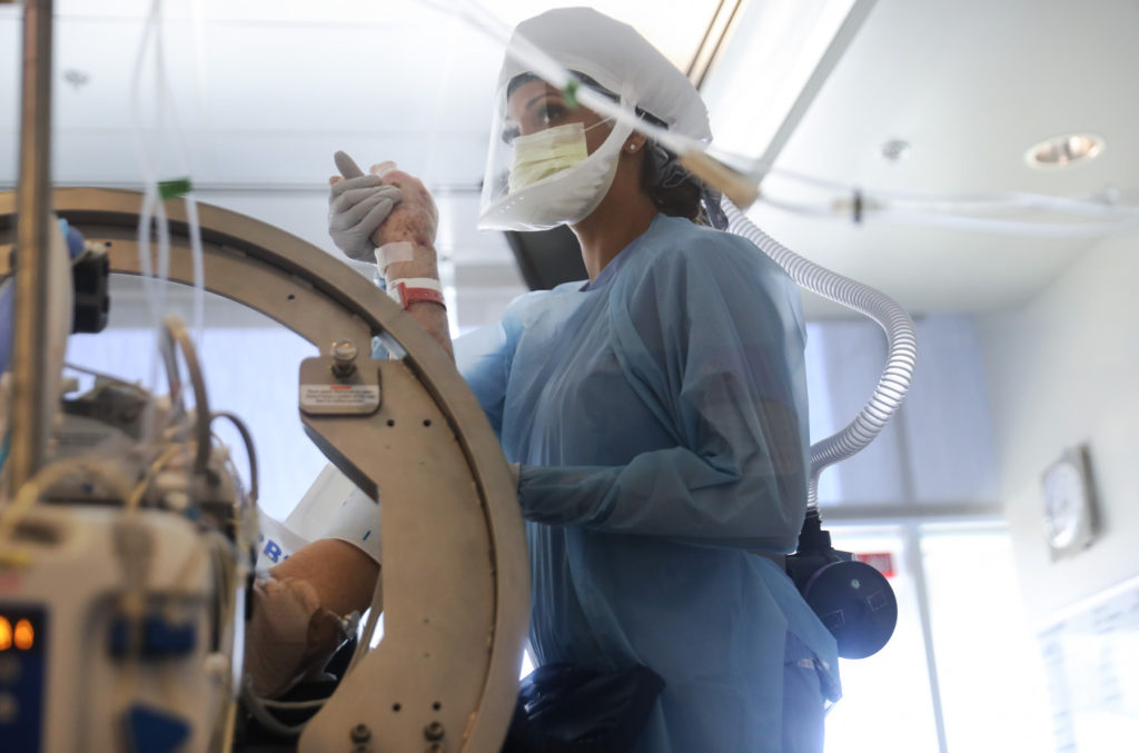 A nurse wears personal protective equipment as she performs range of motion exercises on a COVID-19 patient in the Intensive Care Unit (ICU) at Sharp Grossmont Hospital amidst the coronavirus pandemic on May 5, 2020 in La Mesa, California. Photo by Mario Tama/Getty Images.