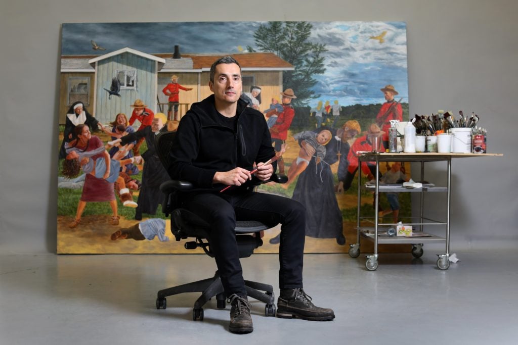 Kent Monkman, a Canadian artist of Cree ancestry, poses with one of his large-scale history paintings, The Scream. (Randy Risling/Toronto Star via Getty Images)