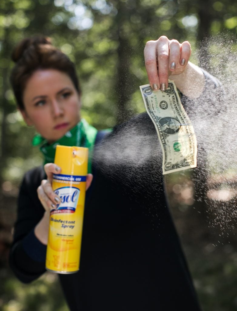 Katherine McMahon sanitizing currency for Free Clean Money. Photo by Jessica Dalene.