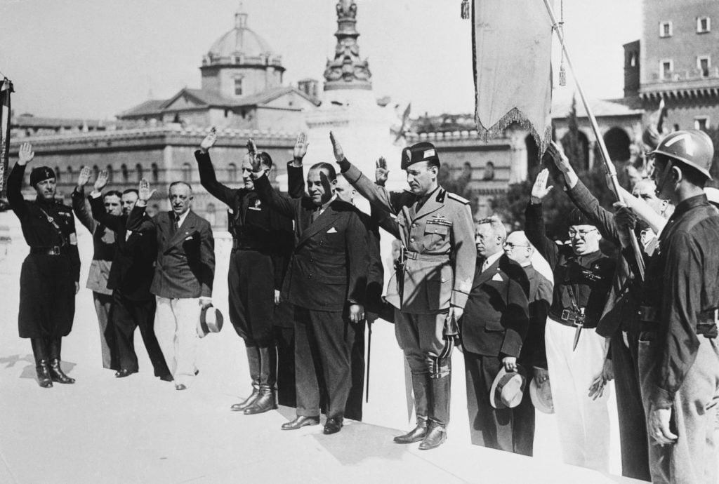 Italian-American newspaper publisher Generoso Pope, in business suit at center of group, with fascist director Falbo, left, and Thaon Di Revel, right, after having decorated the Tomb of the Unknown Soldier in Rome, Italy, on his recent visit. Image courtesy Getty Images.