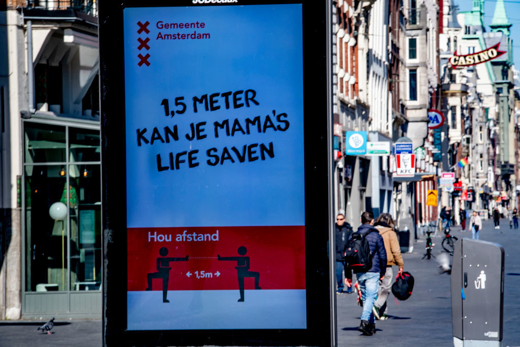 A sign from the city of Amsterdam that reads: 1.5 meters can save your mama's life. Photo by Robin Utrecht/SOPA Images/LightRocket via Getty Images.
