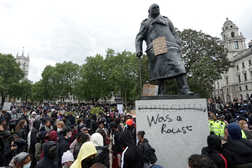 The statue of former British prime minister Winston Churchill is seen defaced, with the words (Churchill) "was a racist" written on it's base in Parliament Square, central London after a demonstration outside the US Embassy, on June 7, 2020. Photo by Isabel Infantes/AFP via Getty Images.