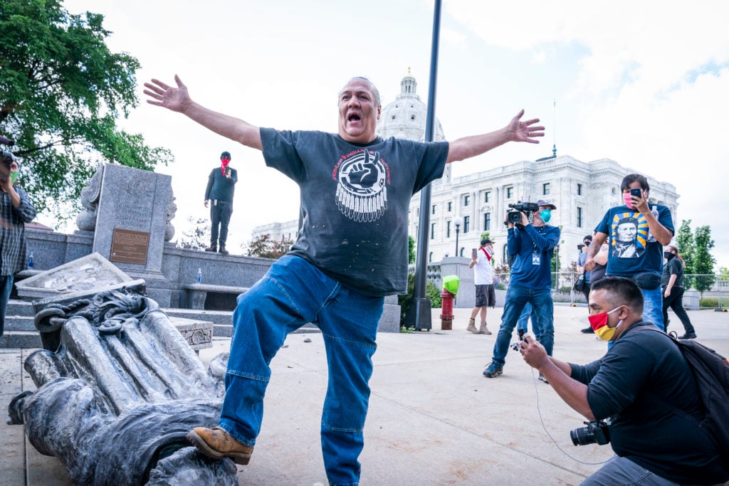 Mike Forcia, of the Black River Anishinabe, celebrated after the Christopher Columbus statue was toppled in front of the Minnesota State Capitol in St. Paul on Wednesday, June 10, 2020. Photo by Leila Navidi/Star Tribune via Getty Images.