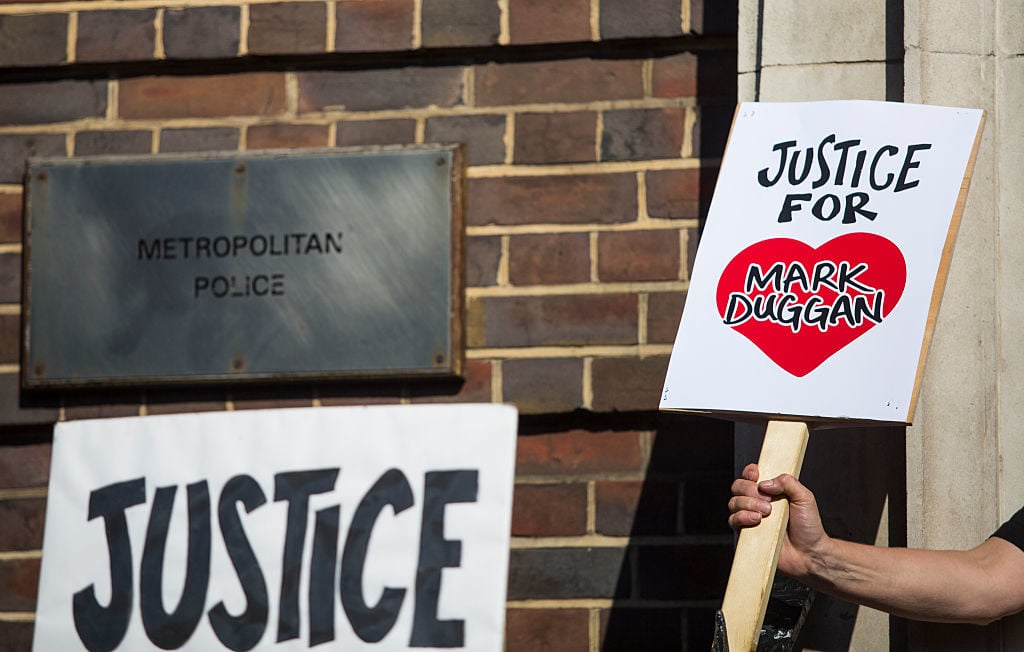 A protester holds up a placard saying 'Justice For Mark Duggan' during a demonstration outside Tottenham Police Station to mark the fifth anniversary of Mark Duggan's death. Photo by Jack Taylor/Getty Images.