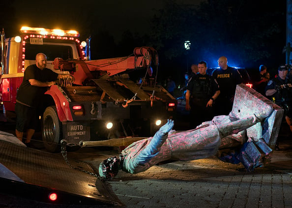 A statue of Confederate President Jefferson Davis is loaded onto a tow truck after it was pulled down off of it's pedestal on Monument Avenue in Richmond, VA on June 10, 2020. Photo courtesy of the Washington Post via Getty Images.